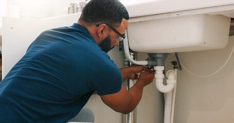 plumber inspecting a blocked commercial sink